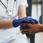 blue-gloves-two-doctors-are-holding-hands-indoors-2024-02-28-19-52-56-utc