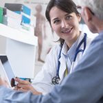 Doctor sharing health information on digital tablet with patient in clinic